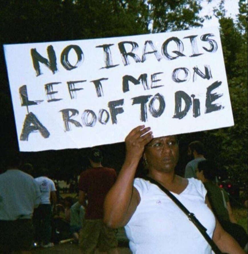 A woman at a rally against the war in Iraq holding a sign about the tragedy after Hurricane Katrina, Washington, 2005.